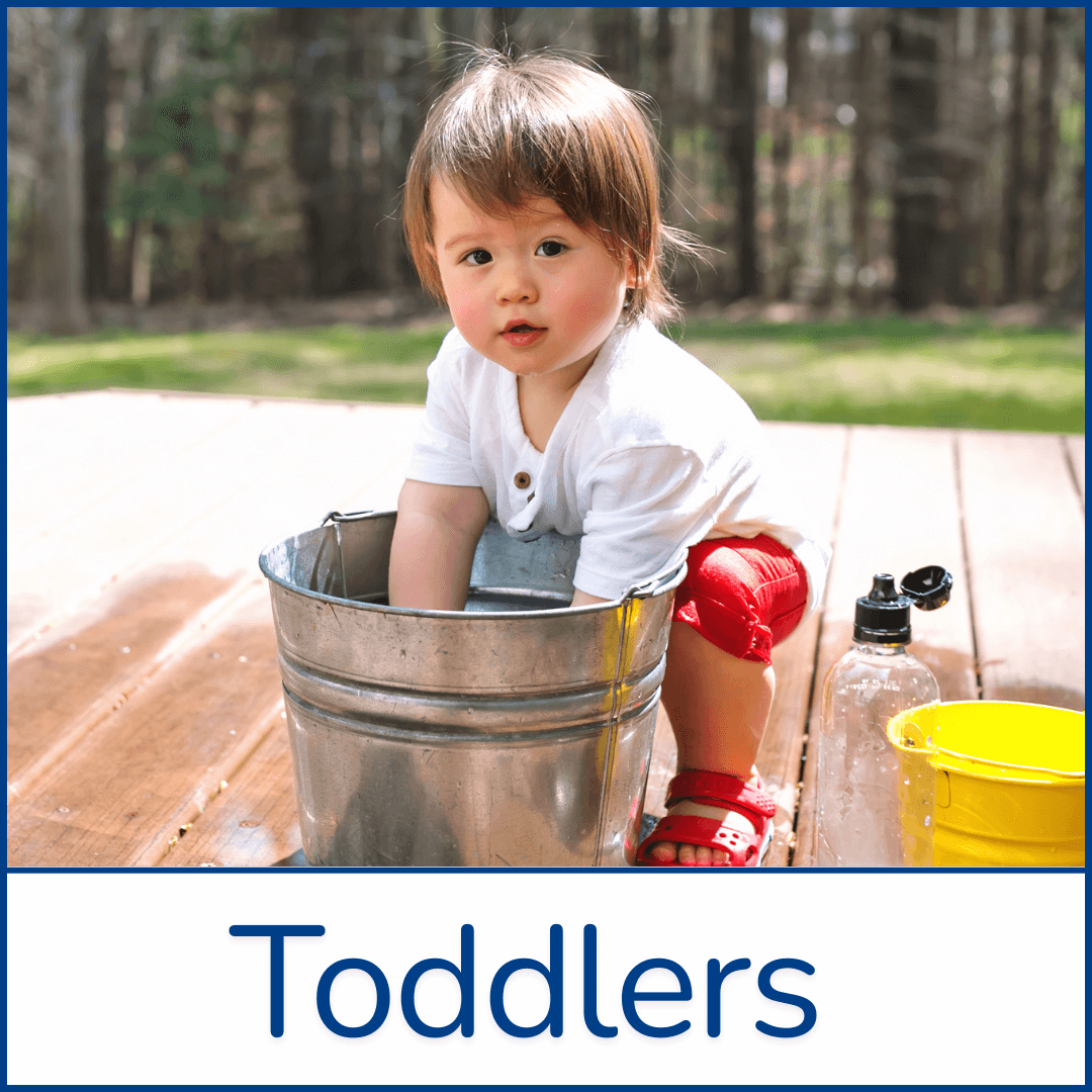 Toddler sitting outdoors playing with a water bucket on a sunny day, symbolizing childhood playtime, milestones, early learning, daycare support, parenting tips raising active, curious, joyful kids Toddler parenting and milestones | Early development, playtime, daycare, and raising happy kids
